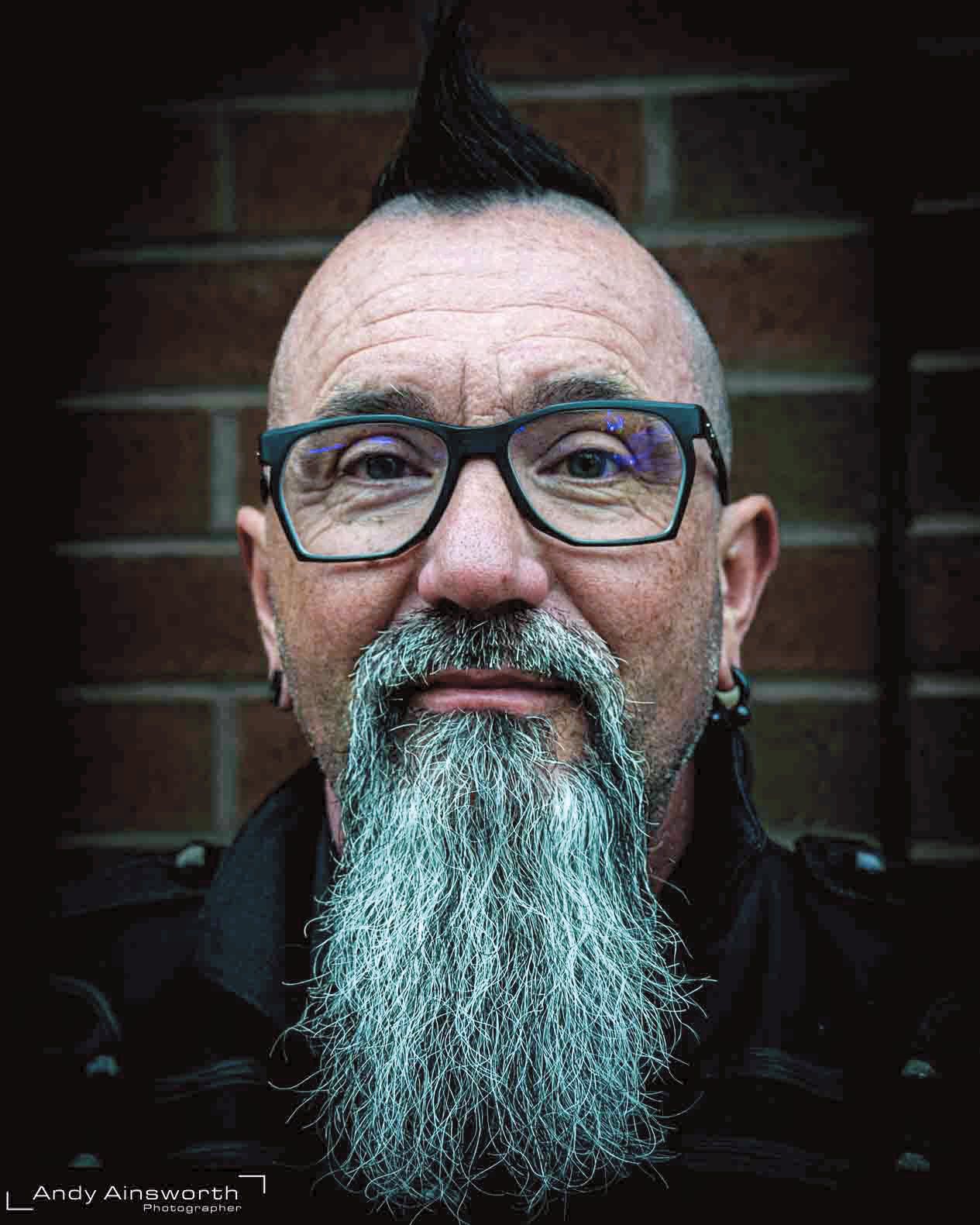 Smiling man with a mohawk, glasses and long grey beard — Whitby Goth Weekend