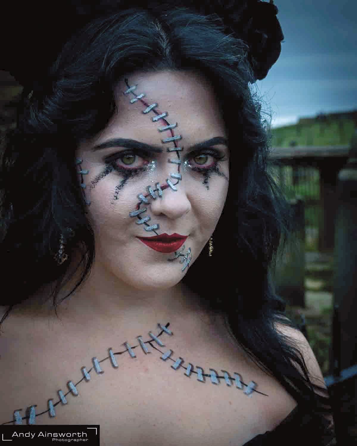 Woman with painted stitch-scar make-up across her face and shoulders — Whitby Goth Weekend