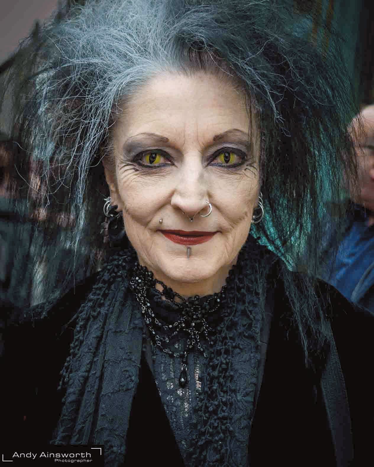 Woman with wild teal-grey hair, green eyes and Victorian dress, smiling — Whitby Goth Weekend
