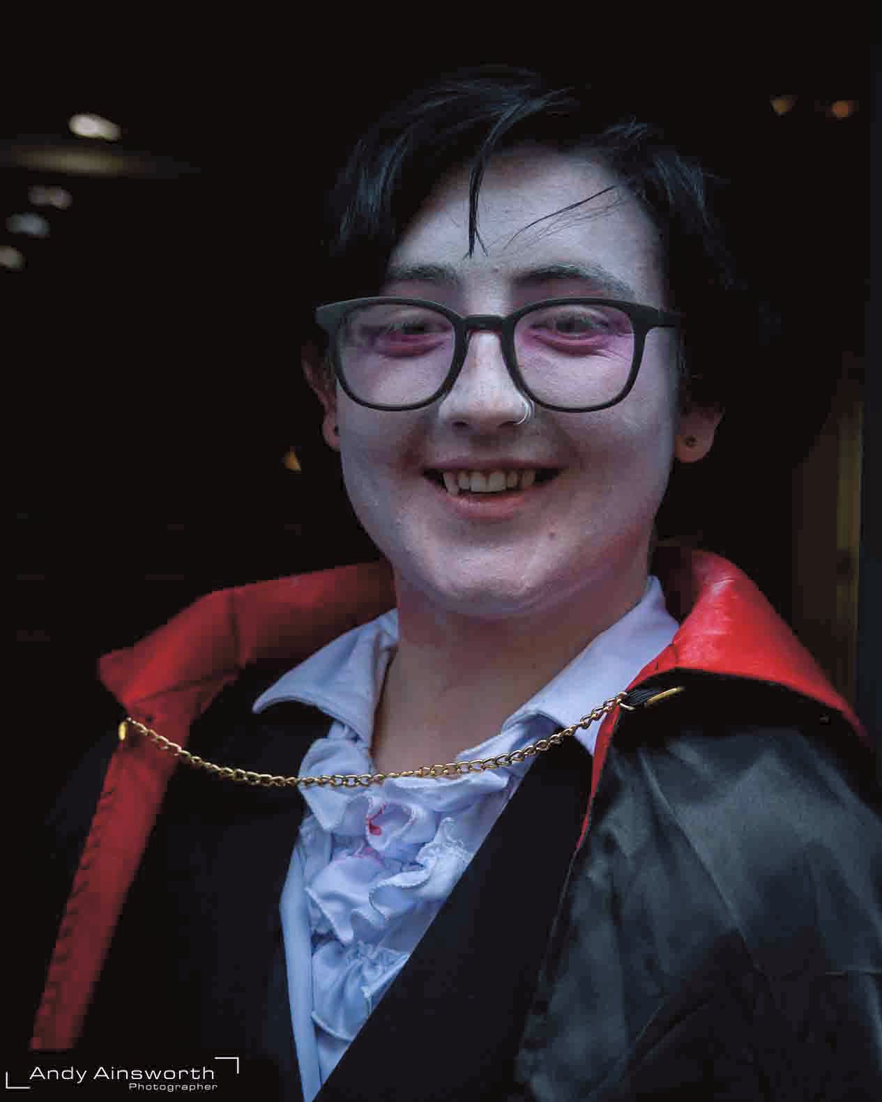 Smiling young vampire in cape and glasses with pale face paint — Whitby Goth Weekend