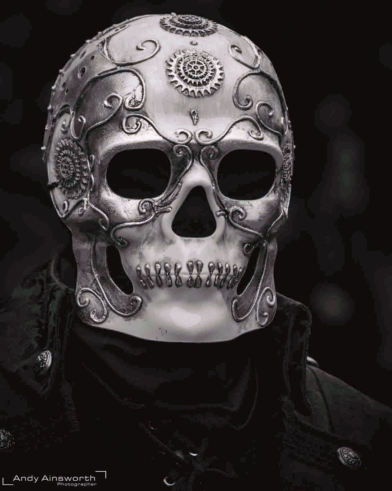 Ornate engraved silver skull mask worn with a black hood, black and white — Whitby Goth Weekend