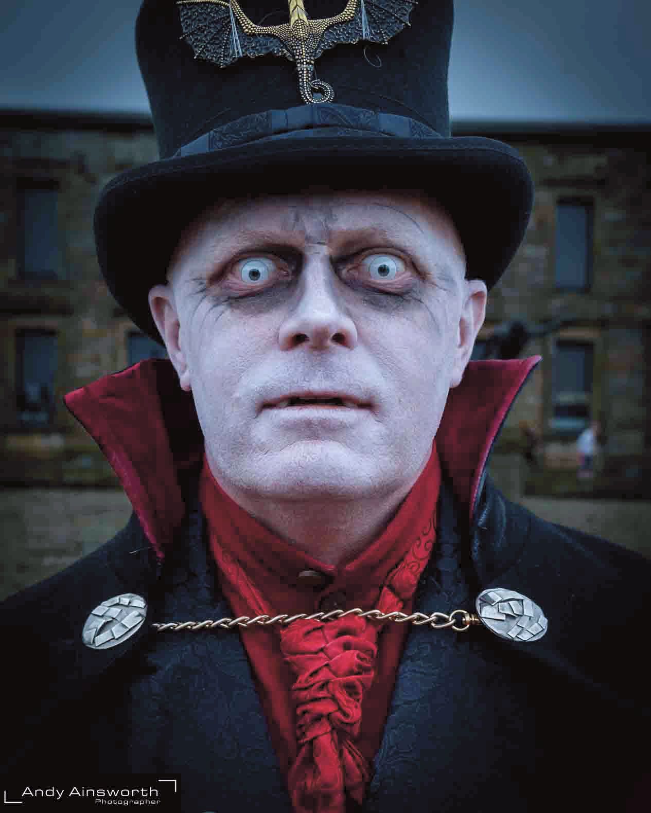 Vampire in a black top hat and red cravat with pale contact lenses — Whitby Goth Weekend