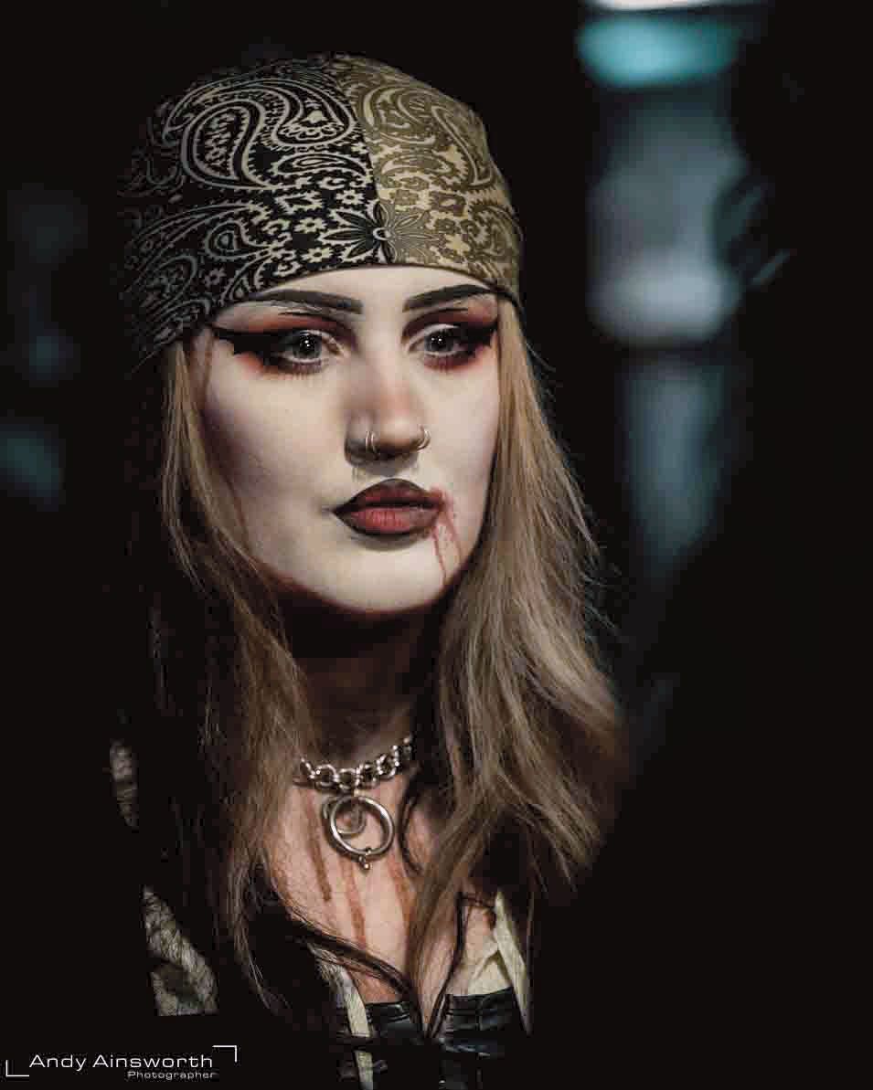 Woman in a patterned headscarf with pale make-up and layered necklaces — Whitby Goth Weekend
