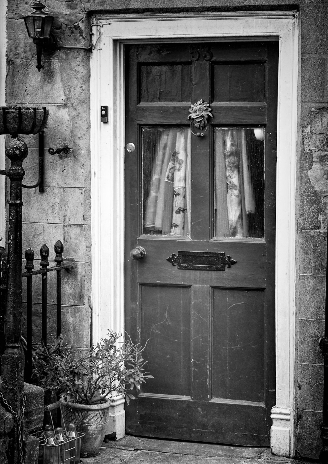 Cottage doorway with lace curtains and potted plants — Knaresborough detail