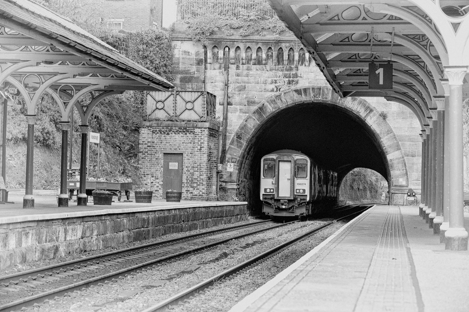 Train waiting at the tunnel mouth under the station canopy — Knaresborough