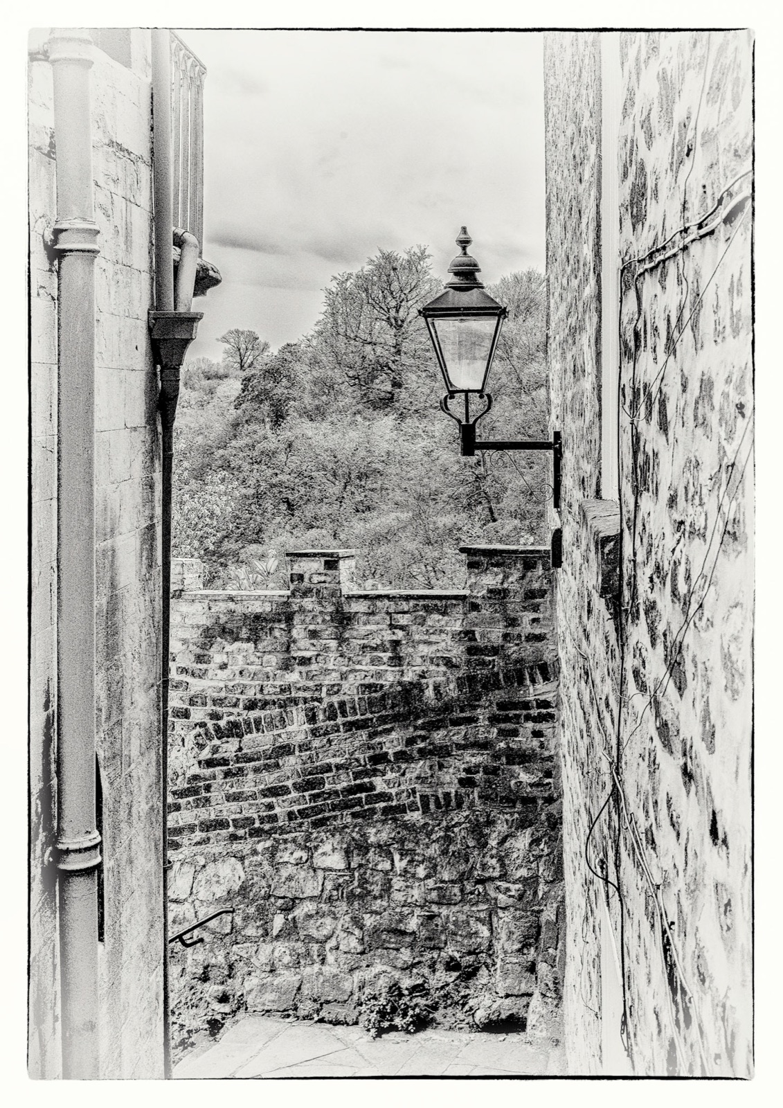 Lamp post and stone wall above the rooftops tumbling downhill — Knaresborough