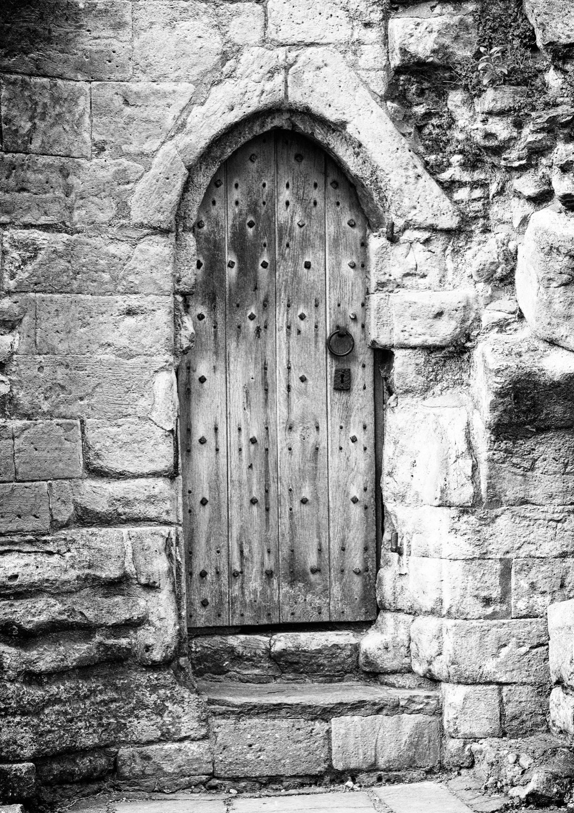 Ancient arched wooden door set in a stone wall — Knaresborough castle detail