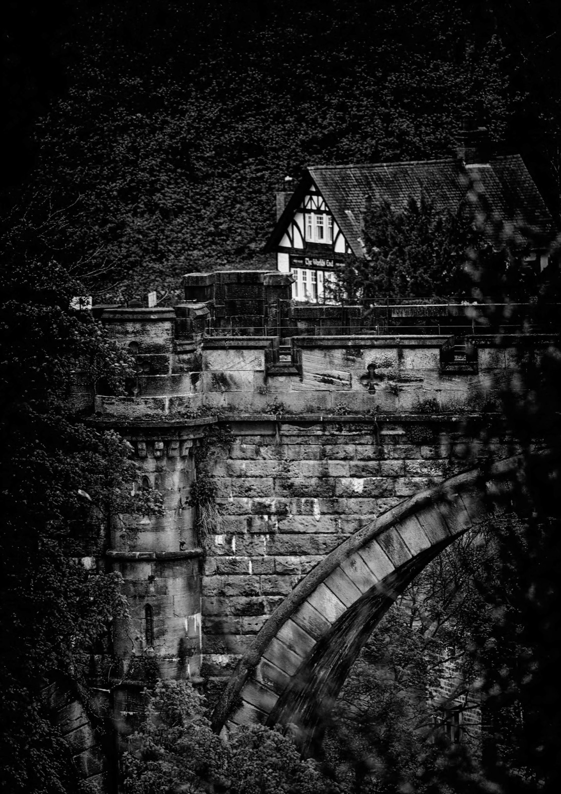 Cottage perched above the viaduct arch in a dark etched vignette — Knaresborough